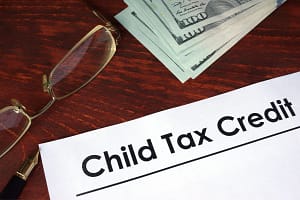 A child tax credit is sitting on top of a pile of money.